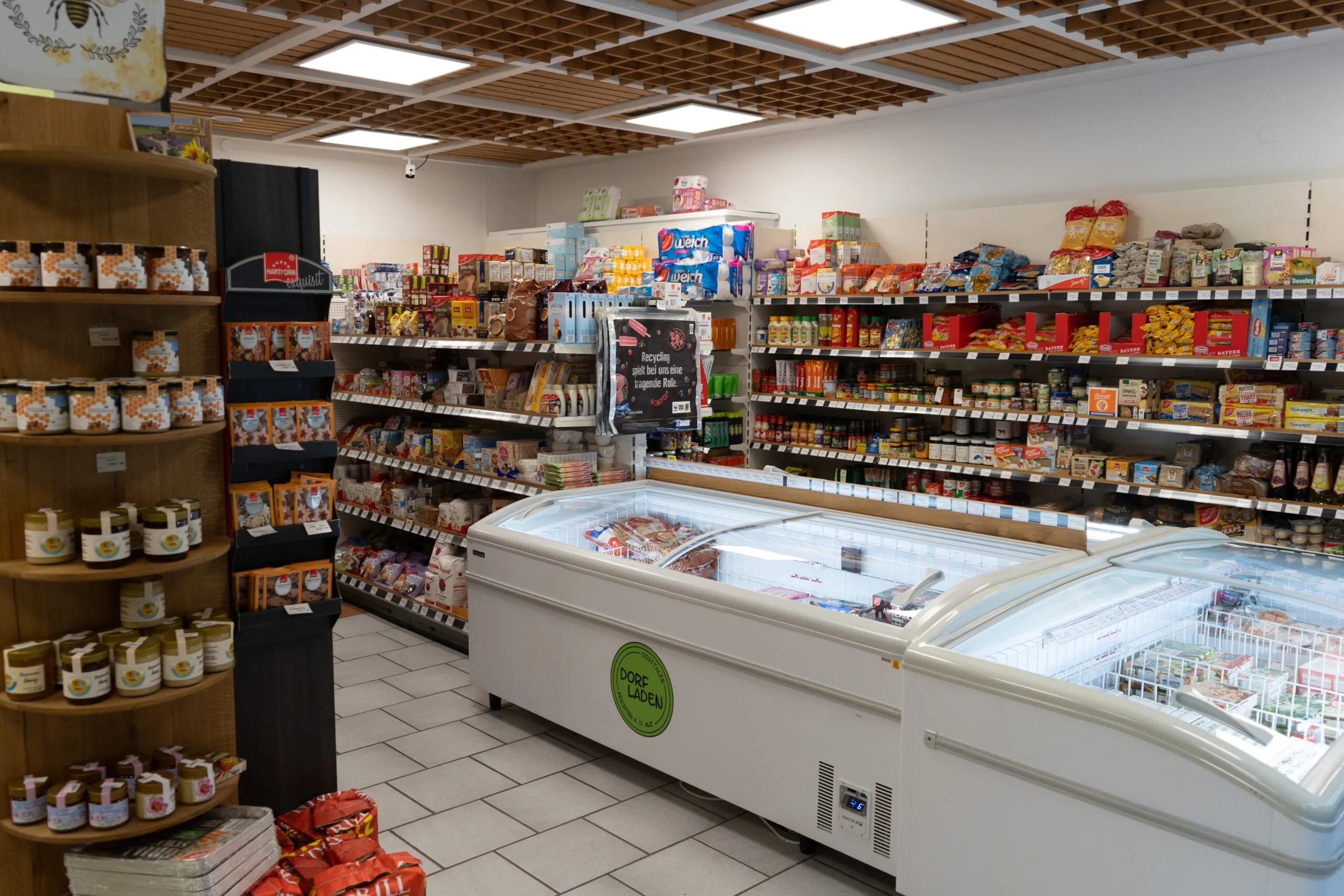 Blick in den Digitalen Dorfladen: Regale mit Lebensmitteln, Kühltruhen und regionalen Produkten